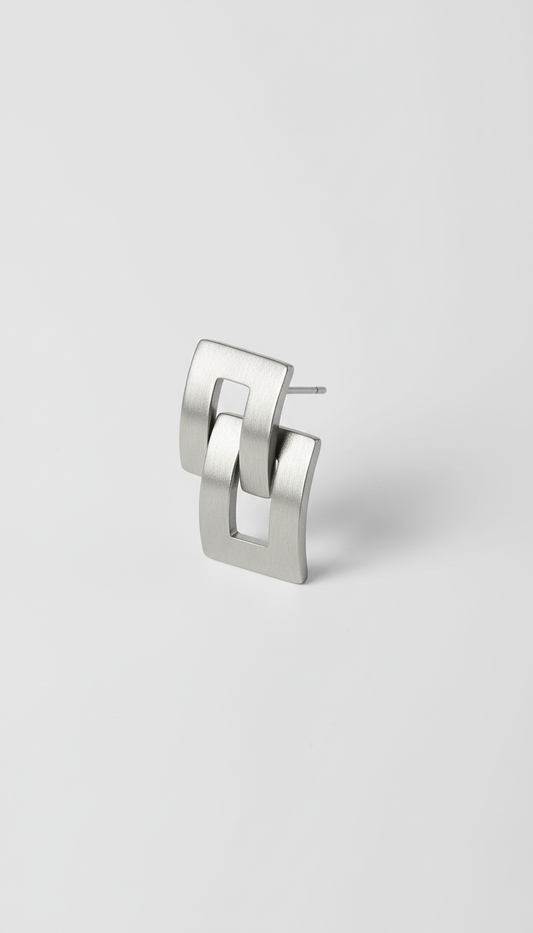 Modern steel earrings, Use a 3/4 angle for product shots, allowing the viewer to appreciate the depth and detail of the...