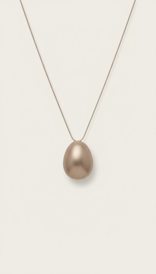 Minimalist Soft Taupe pendant necklace, Hero jewelry pieces captured at 3/4 angle on matte plinths or trays, allowing...